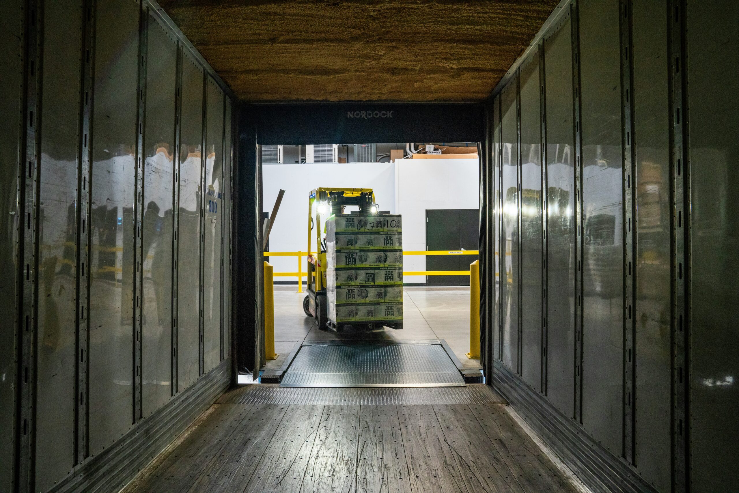 Forklift loading cargo into a shipping truck, symbolizing export compliance and documentation management.