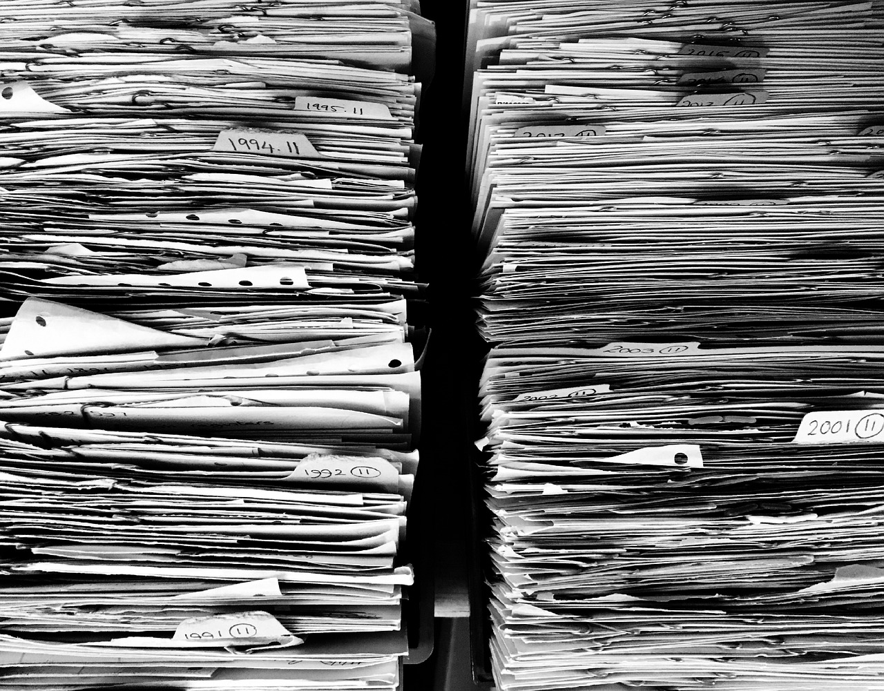 Stacks of organized paperwork representing export documentation and regulatory compliance services.